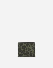 Load image into Gallery viewer, Dauphine calfskin bifold wallet with leopard print against a green background