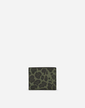 Load image into Gallery viewer, Dauphine calfskin bifold wallet with leopard print against a green background

